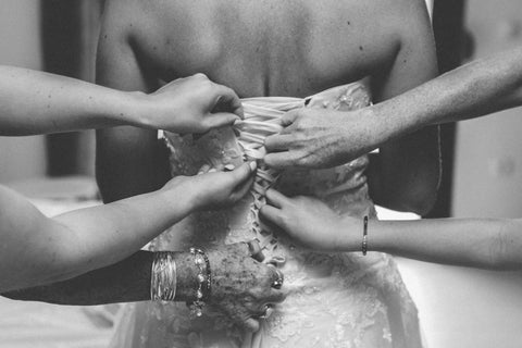 women helping bride dress