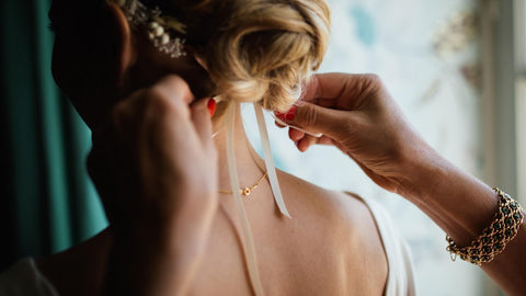 bride with hair up, hands ribbon 