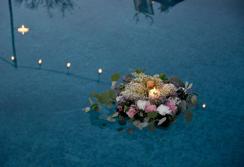 flowers and candle floating in water 
