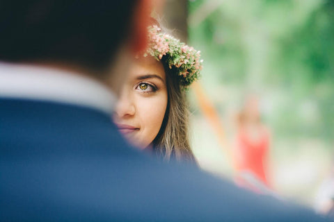 bride in flower crown looking at her groom