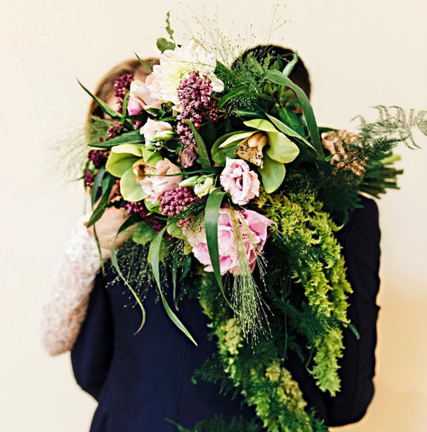 bride and her husband embracing with flowers 