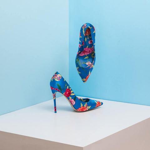 a pair of shoes on white table with blue background