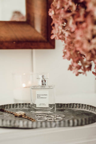 perfume, flowers and jewellery on a table 