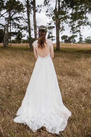 bride in dress standing on grass 