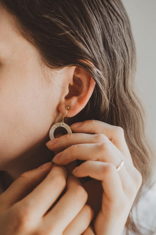 woman putting on an earring