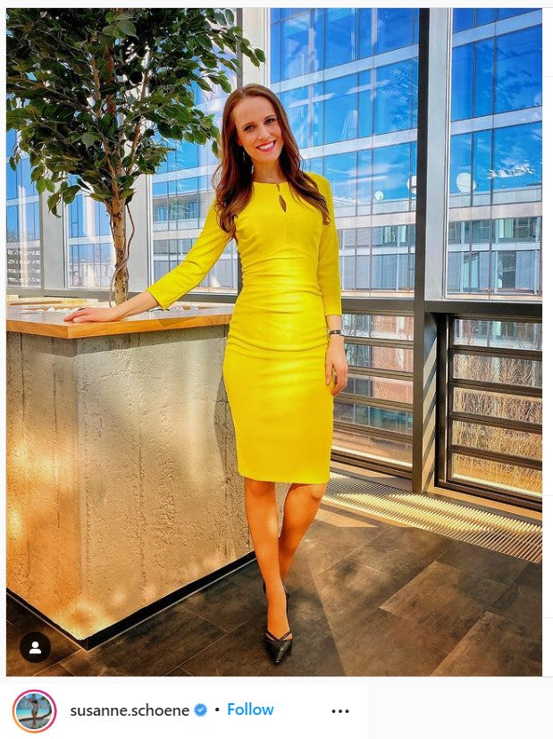 A woman posed in front of a glass window wearing Diva Catwalk's Lakewood Dress.