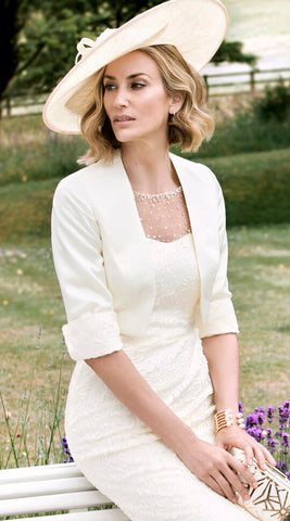 woman dressed in white sitting wearing a hat