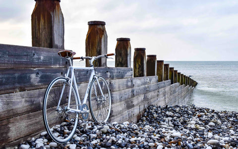 Vélo contre palissade en bois au bord de la mer sur une plage de galets