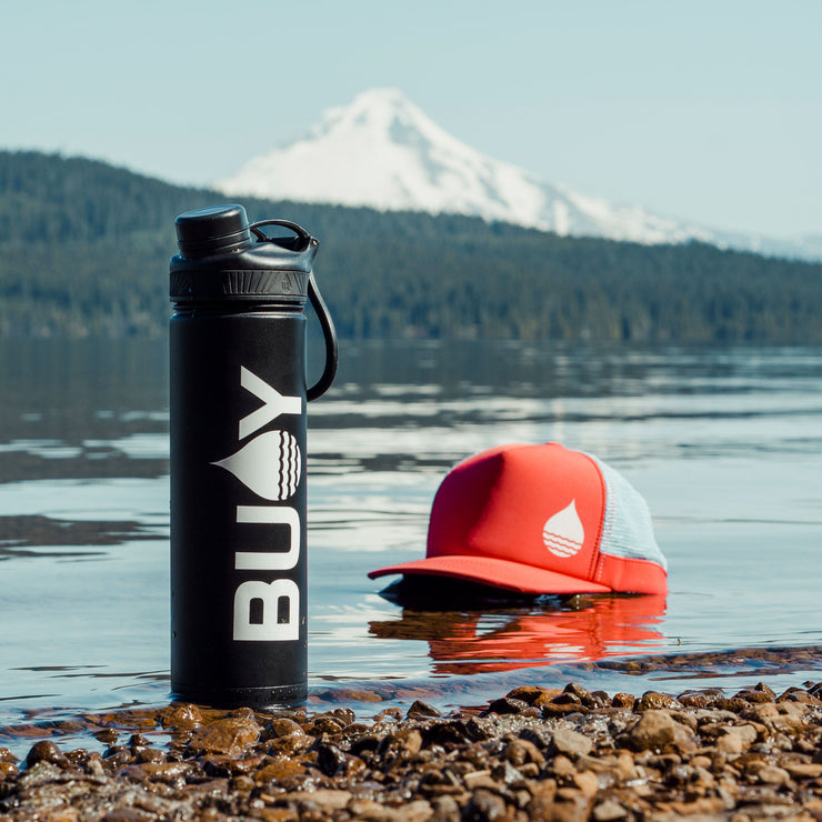 BUOY Brand Logo Transfer Sticker on a coffee mug with a floating hat in the background at Timothy Lake, Oregon - BUOY WEAR