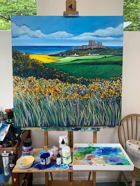 A painting of Bamburgh Castle on and Easel in Joanne Wishart's art studio. 