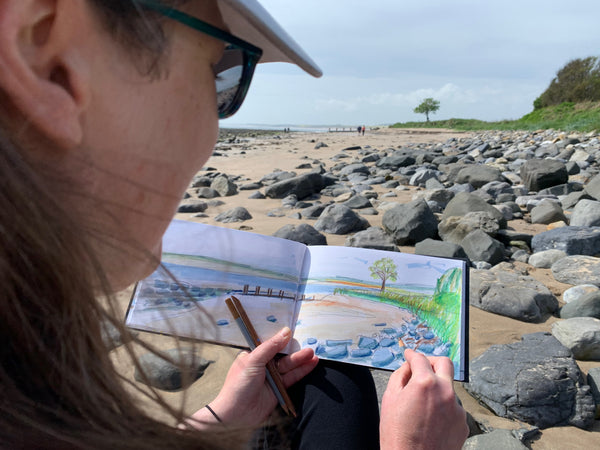 Artist sketcthing on Alnmouth Beach 