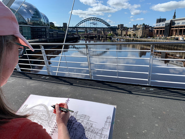 Artist Joanne wishart is sitting sketching on the Millenium Bridge. 