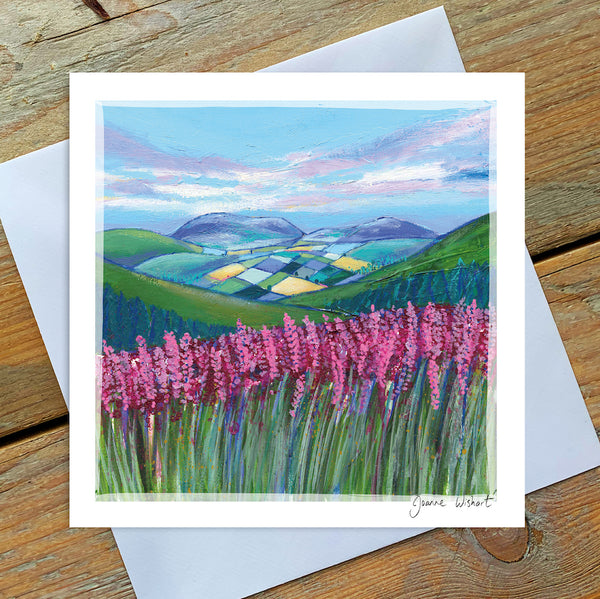 A greetings card showing the warm tones of the purple Northumberland heather in a rolling landscape scene. 