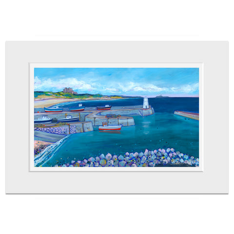 A mounted print of a scene of Seahorses harbour with colourful red boats and Bamburgh Castle and beach in the distance. 