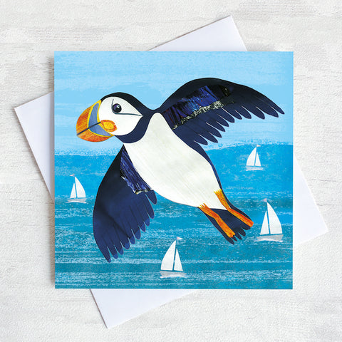 A greetings card featuring a flying puffin over a turquoise sea.