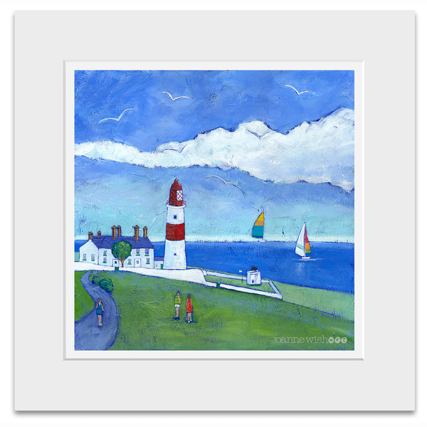 A mounted picture of a red and white lighthouse in a green field with the sea in the distance. 