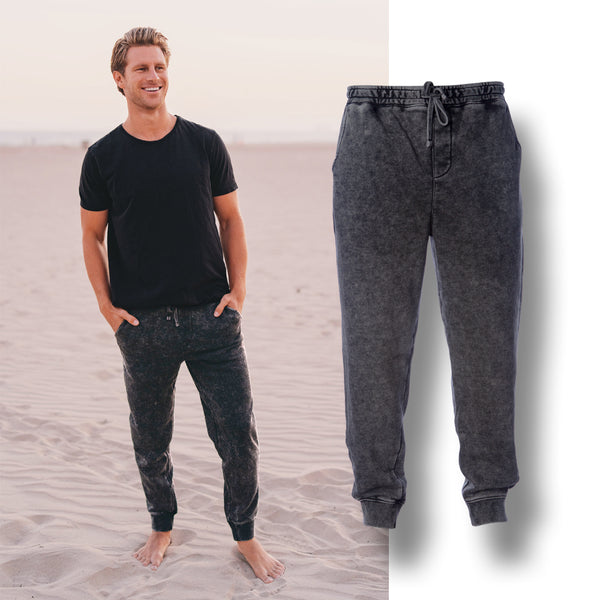 a man standing on the beach wearing a mineral wash fleece pant with a mannequin pant with a drop shadow over the top of the image