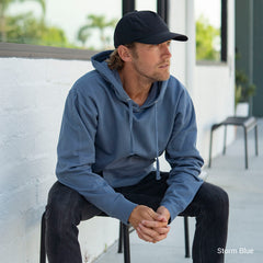 man sitting on a bench wearing a blue SS4500 storm blue midweight hooded sweatshirt