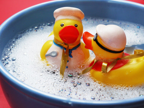 Two rubber ducks swimming in bubble water