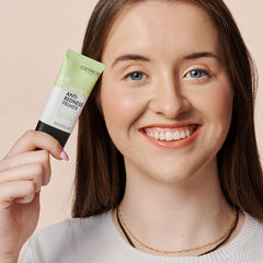Smiling Lady Holding Up Beauty Product