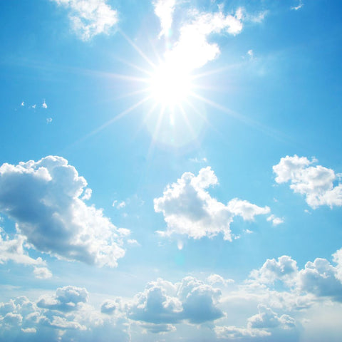 Bright sun in a blue sky with clouds