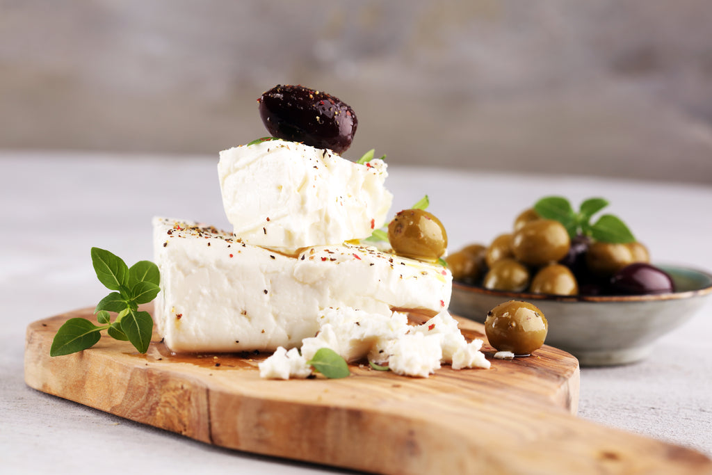 Goat cheese and olives on a cutting board