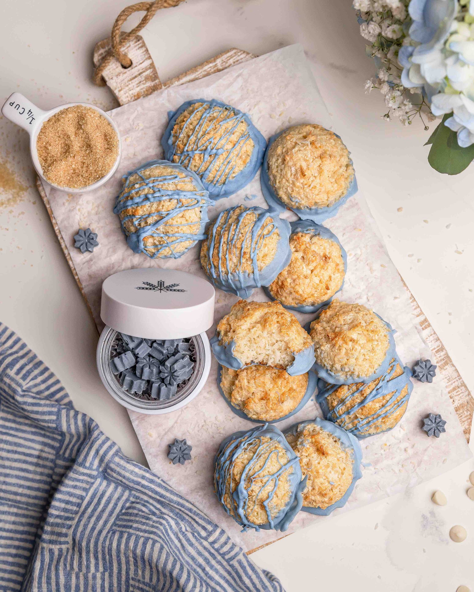 chocolate dipped macaroons diplayed on a white wooden board with a jar of Pantry's blue colored glow bites