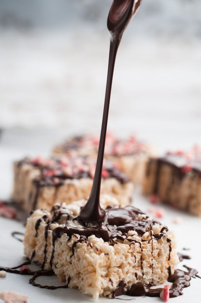 melted chocolate being poured over a fresh rice krispie