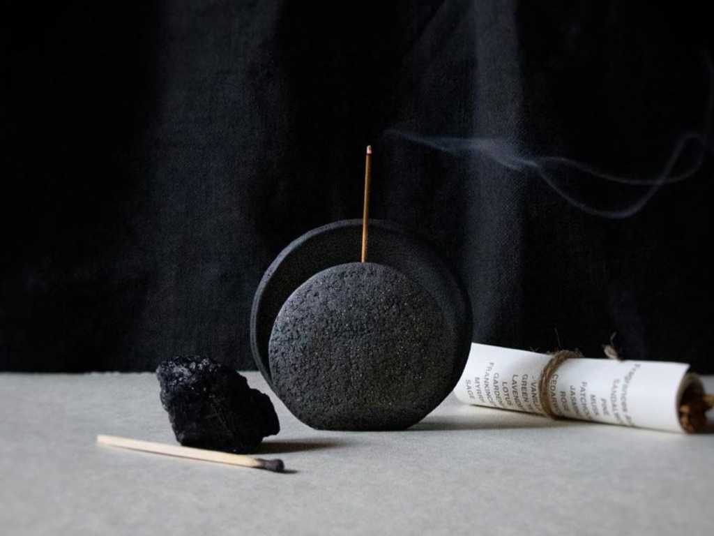 An incense burner in black handmade in ceramic shaped like a half moon