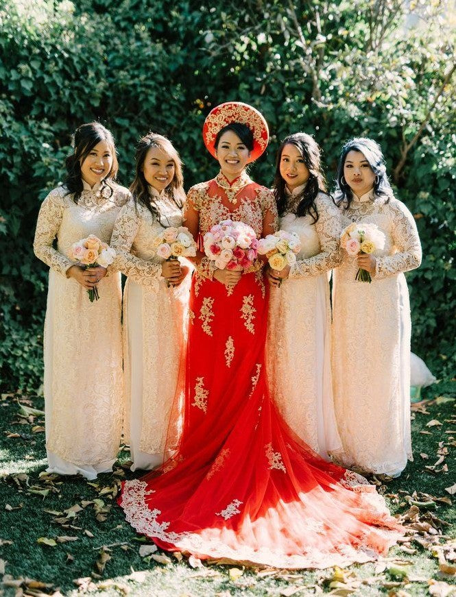Vietnamese bride in a red and gold áo dài with her bridesmaids in soft pink áo dài.