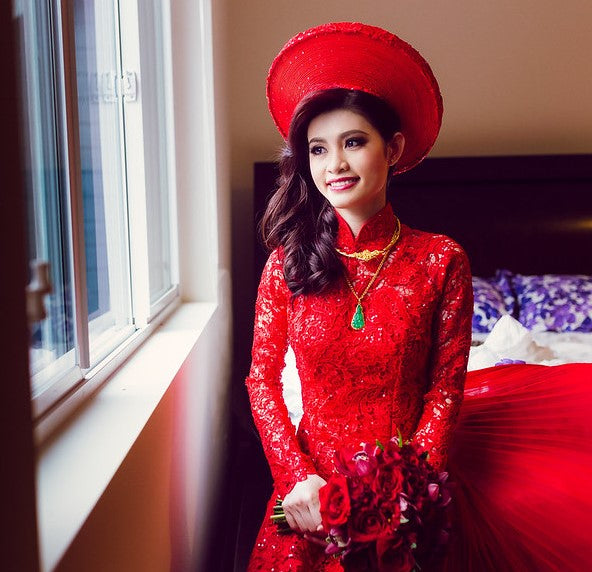 Traditional Vietnamese bride wearing a red wedding áo dài overlaid with red lace.