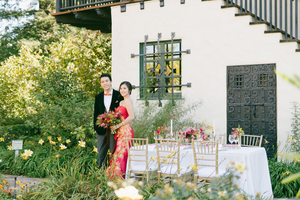 A newlywed couple standing in a garden.