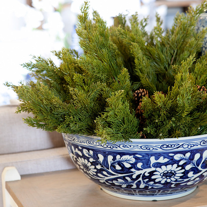 Pine sprays in blue and white bowl.