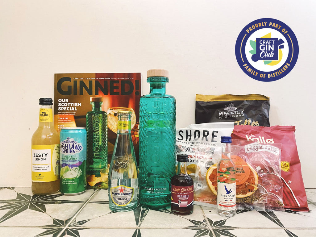 The contents of Craft Gin Club November gin box sit on a tiled surface against a white background. Turquoise Coast and Croft Downpour gin bottle and assorted crisps and mixers.