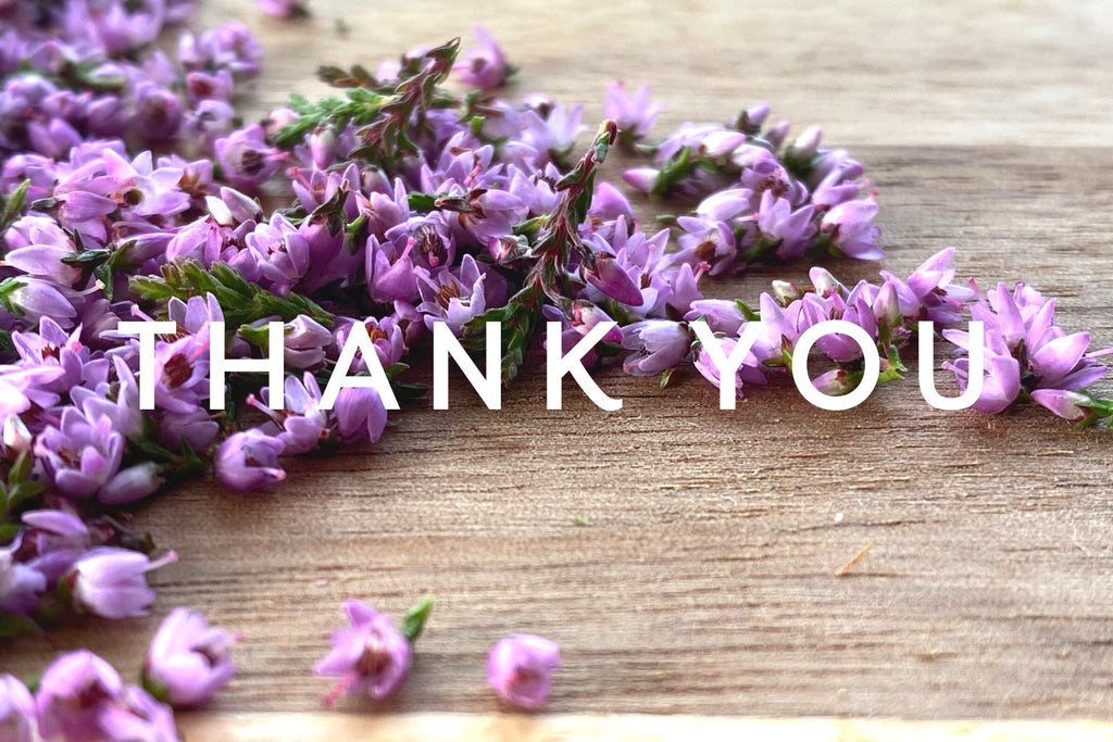 close up of tiny heather blossoms on a wooden board, the words 'thank you' typed over the image 