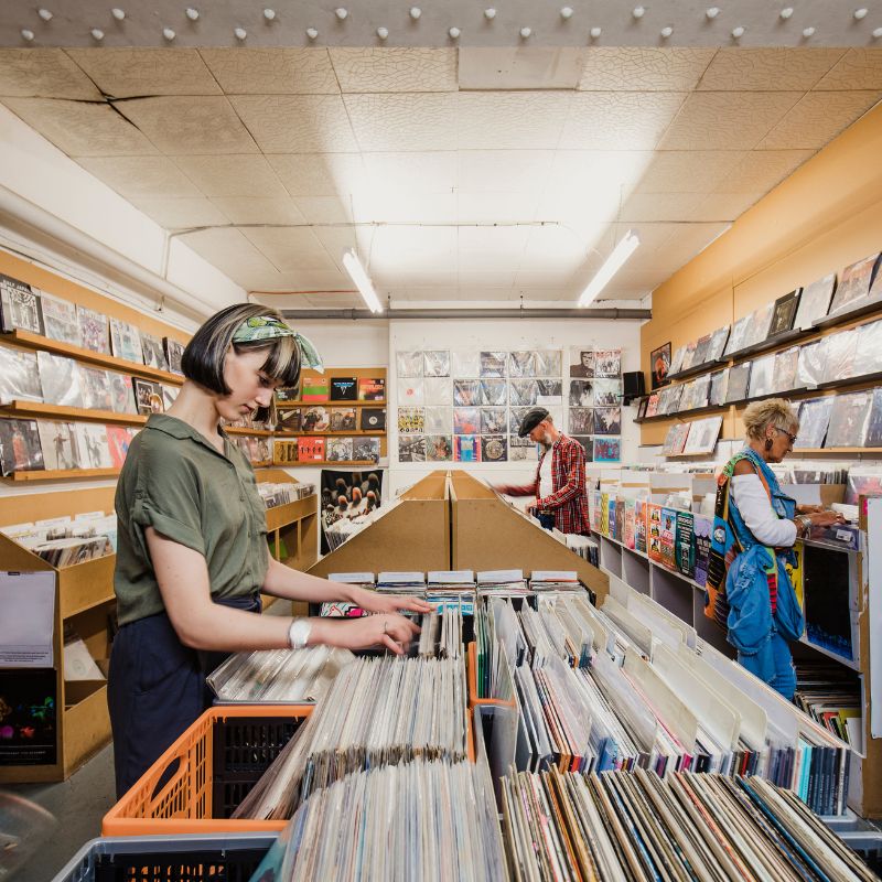 People Browsing Vinyl Records In Record Store