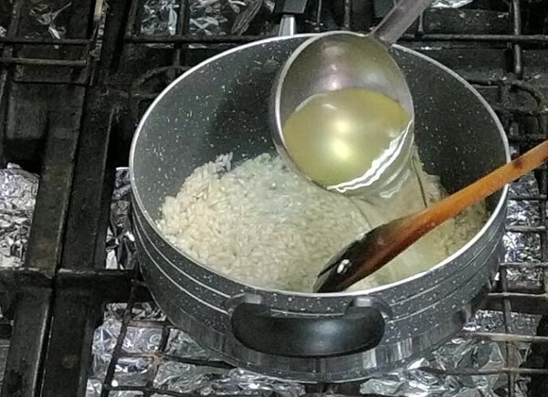 Brodo vegetale aggiunto al riso per la cottura.