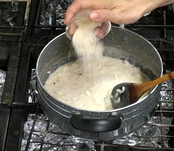 Mantecatura del risotto con 40 g di Grana Padano.