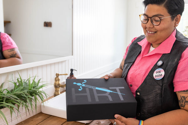 A person opening a box of HRT provided by Folx Health