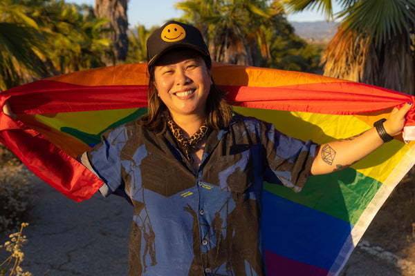 Queer person from FOLX health holding rainbow flag