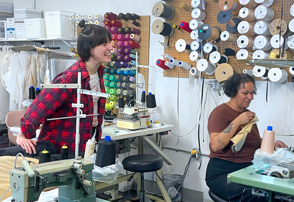 Two Origami Customs Employees working in the clothing studio