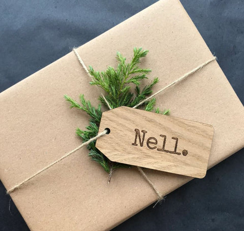 Gift wrapped in brown paper tied with string and with personalised gift tag and foliage