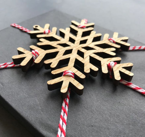 Gift wrapped in tissue with wooden snowflake 