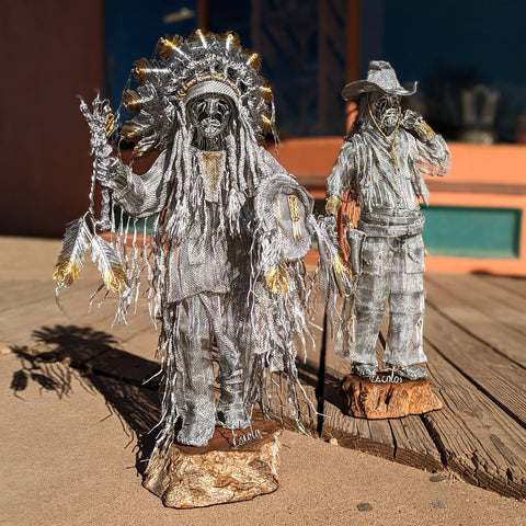  Wire sculpture of Native American and Cowboy figures by Lui Escoto outside on a wooden boardwalk