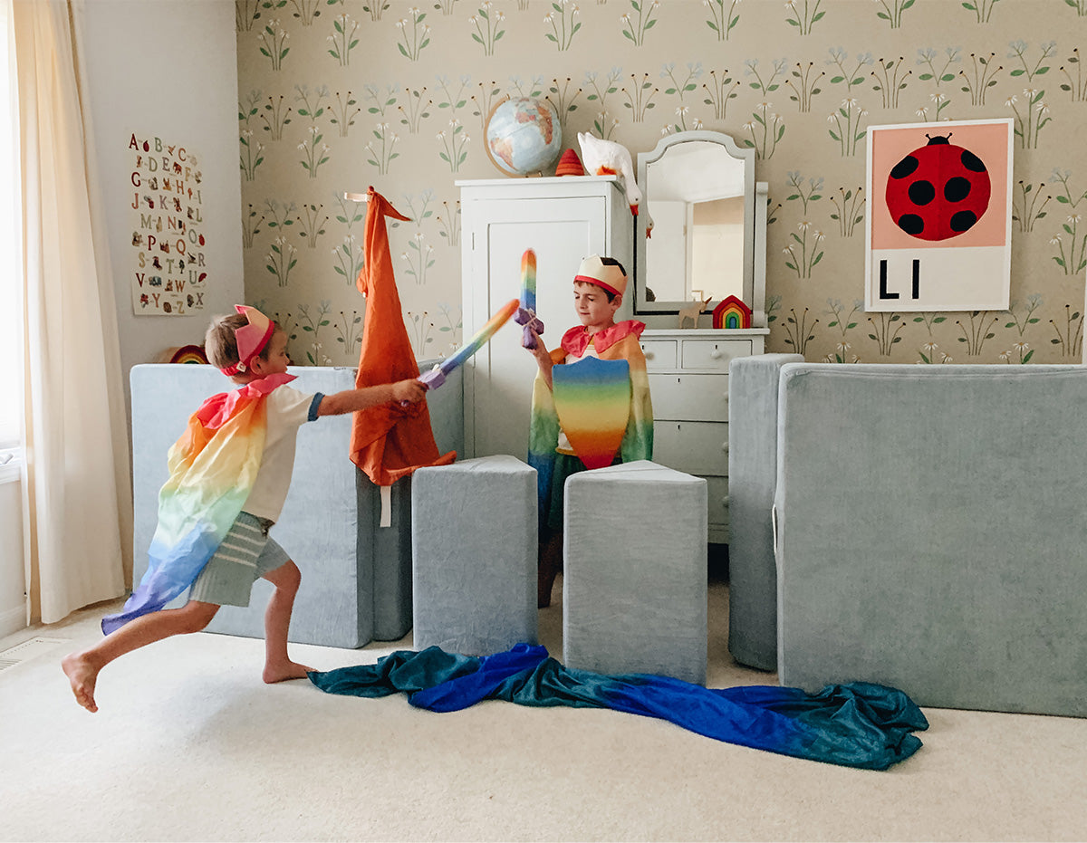 A Surfside Nugget is set-up with pillows as turrets while two children in crowns play behind it