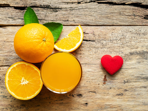 A glass of fresh orange juice and group of fresh orange fruits with green leaves - InterPlexus Blog