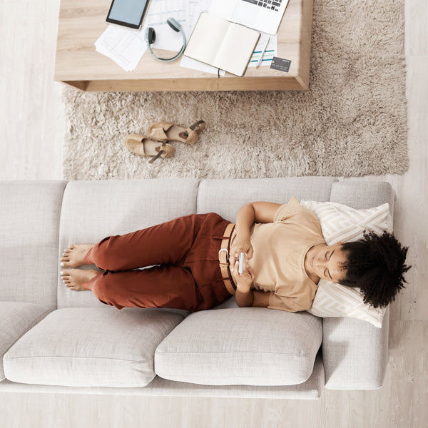 Woman with smartphone, relaxing on couch