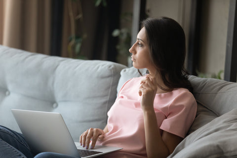 Pensive woman work on laptop at home