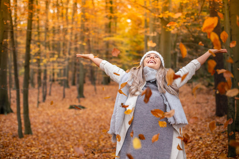 Bundled Up Woman with Healthy Blood Pressure Spreading Joy While Hiking in the Fall Forest