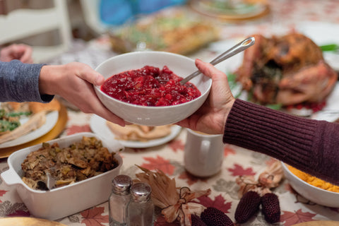 Family Passing Warm Organic Paleo Vegan Cranberry Sauce Recipe Around the Holiday Table - Fall Superfood